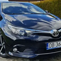 Lśniący czarny Toyota Auris z tablicą DB 3667M. Silnik pracuje cicho dzięki najlepszemu olejowi 5w30.