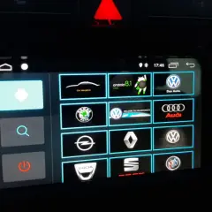 Ekran multimedialny z ikonami marek samochodów i opcją android auto ustawienia.