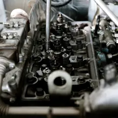 Mechanik diagnozuje stukanie w silniku, badając zawory i wtryskiwacze.