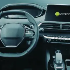 Wnętrze samochodu z widocznym ekranem multimedialnym z logo Android. Dowiedz się, jak włączyć Android Auto.