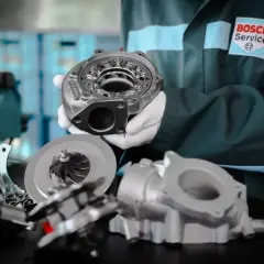 Mechanik w rękawiczkach prezentuje turbosprężarkę, kluczowy element, który daje turbo w samochodzie większą moc i dynamikę.