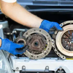 Mechanik pokazuje zużyte części: sprzęgło i dwumasę. Dowiedz się, ile kosztuje wymiana sprzęgła i dwumasy.