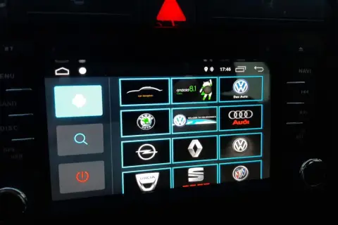 Ekran multimedialny z ikonami marek samochodów i opcją android auto ustawienia.