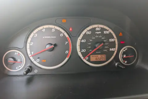 Kontrolki na desce rozdzielczej Hondy CR-V: świeci się kontrolka VSA, ABS, hamulców. Temperatura zewnętrzna 90°F, przebieg 165895.