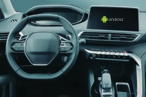 Wnętrze samochodu z widocznym ekranem multimedialnym z logo Android. Dowiedz się, jak włączyć Android Auto.