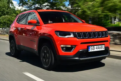 Pomarańczowy Jeep Compass w ruchu. Czy warto kupić ten SUV? Stylowy wygląd i komfort jazdy.