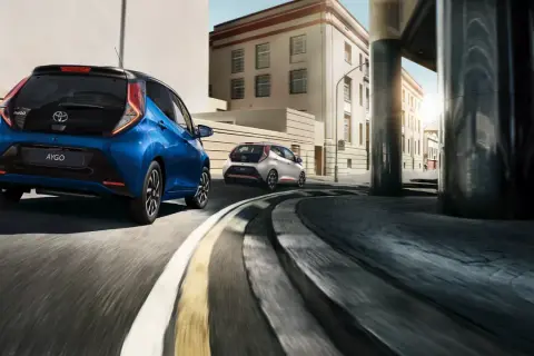 Dwa samochody Toyota Aygo jadące ulicą. Zastanawiasz się, ile pali Toyota Aygo?