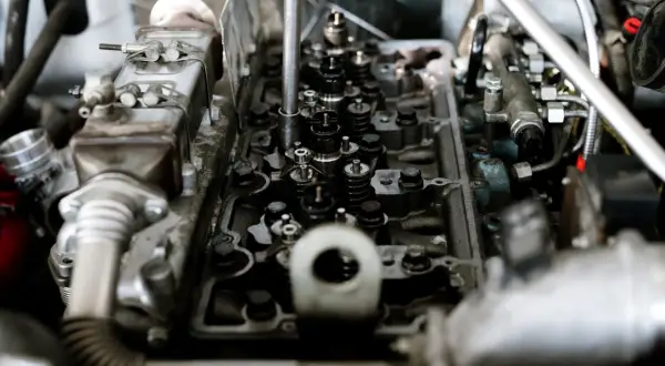 Mechanik diagnozuje stukanie w silniku, badając zawory i wtryskiwacze.