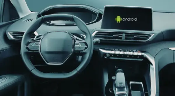 Wnętrze samochodu z widocznym ekranem multimedialnym z logo Android. Dowiedz się, jak włączyć Android Auto.