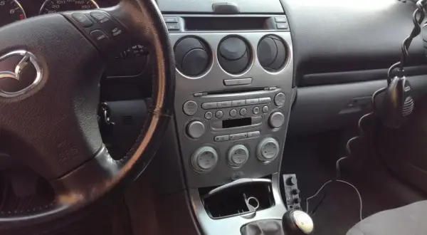 Wnętrze samochodu z widocznym radiem i kierownicą. Jeśli masz problem, jak zresetować bluetooth w samochodzie, sprawdź instrukcję obsługi lub poszukaj opcji w menu systemu multimedialnego.