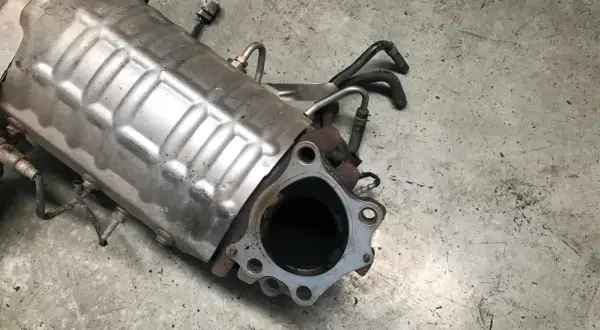 Filtr DPF Ford Focus MK2 z widocznymi przewodami. Zastanawiasz się, jak dolać płyn do DPF? Ten element jest kluczowy.