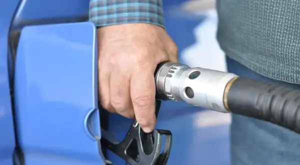 Dłoń trzymająca pistolet do tankowania LPG. Wymiana filtra gazu to ważny element dbania o samochód.