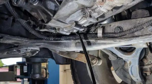 Wymiana oleju w skrzyni manualnej Honda CRV. Widać lejek wlewający nowy olej do skrzyni biegów.