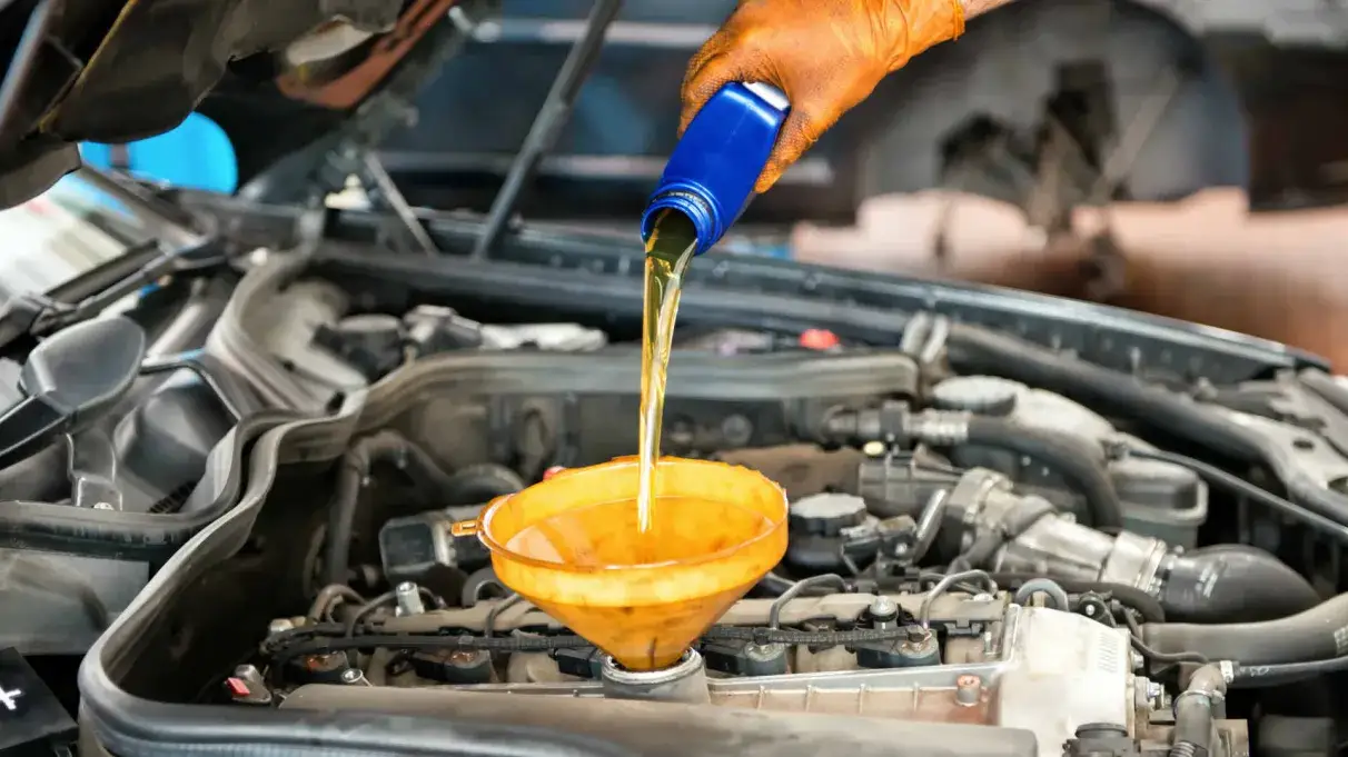 mechanik wymieniający olej w samochodzie na podnośniku