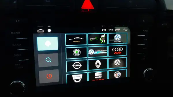 Ekran multimedialny z ikonami marek samochodów i opcją android auto ustawienia.