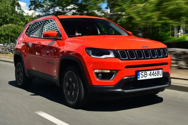 Pomarańczowy Jeep Compass w ruchu. Czy warto kupić ten SUV? Stylowy wygląd i komfort jazdy.