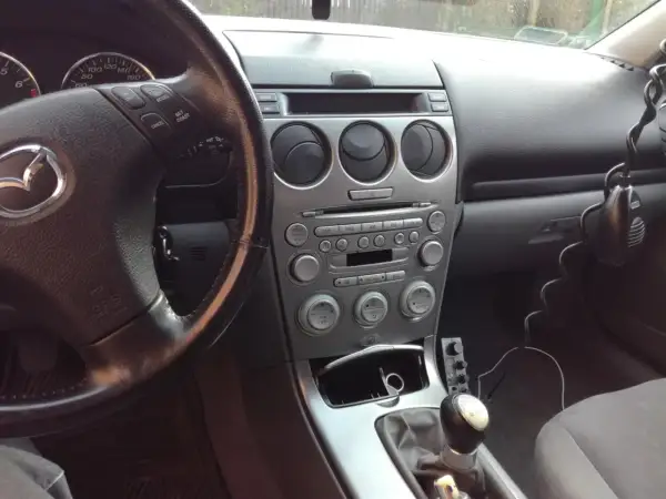 Wnętrze samochodu z widocznym radiem i kierownicą. Jeśli masz problem, jak zresetować bluetooth w samochodzie, sprawdź instrukcję obsługi lub poszukaj opcji w menu systemu multimedialnego.