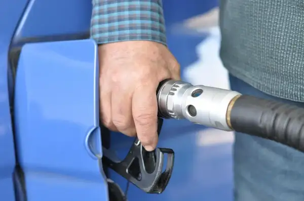 Dłoń trzymająca pistolet do tankowania LPG. Wymiana filtra gazu to ważny element dbania o samochód.