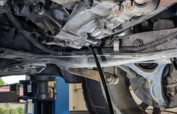 Wymiana oleju w skrzyni manualnej Honda CRV. Widać lejek wlewający nowy olej do skrzyni biegów.